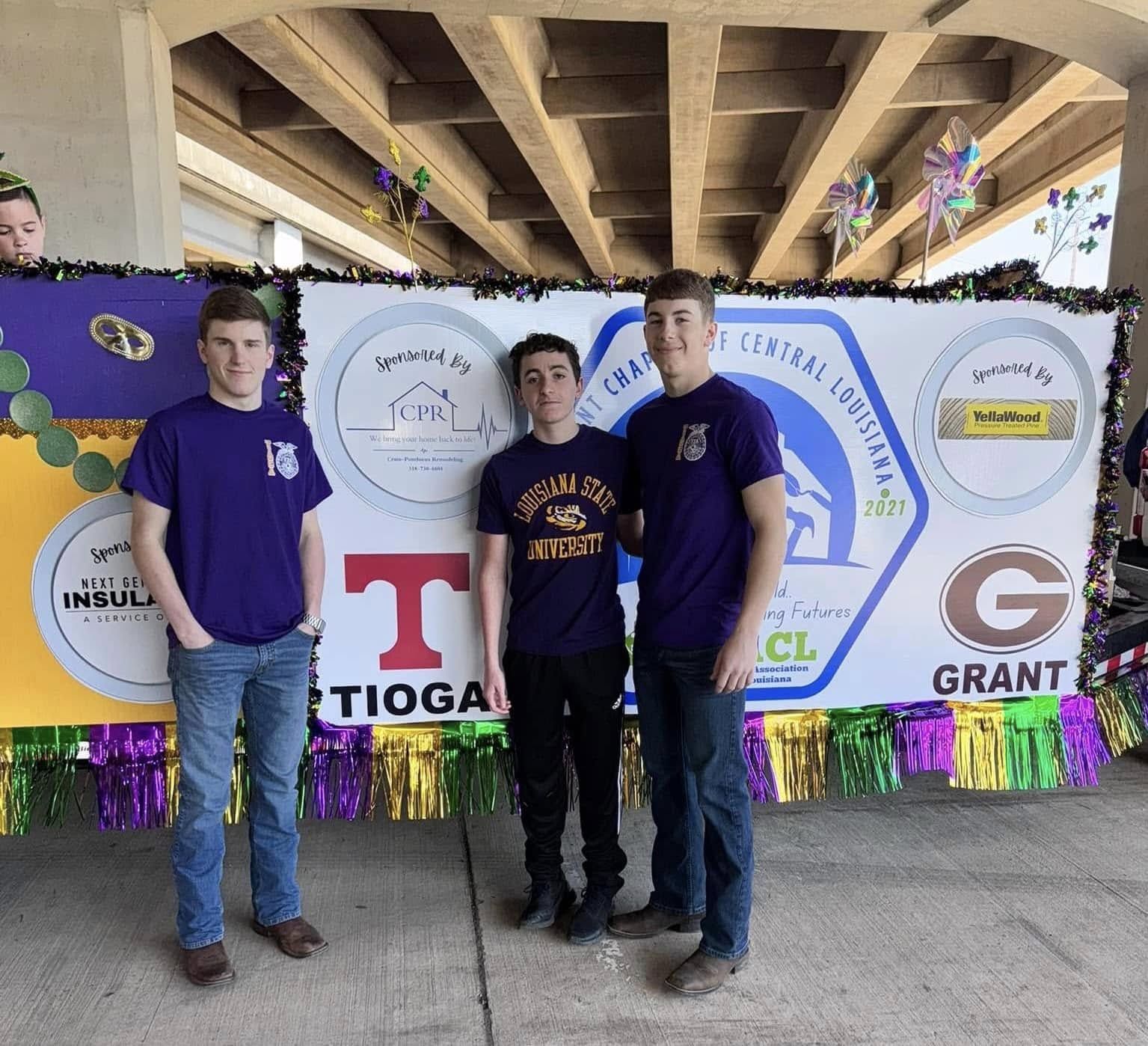 Students in matching shirts in front of the chapter Mardi Gras float